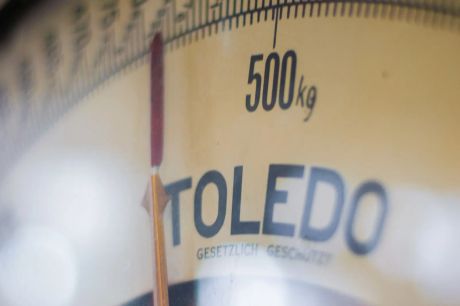 Yellow analogue weight scale display with the needle position just before 500 kg.