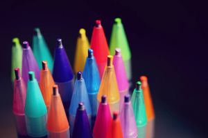 Multi-coloured pens against a black background
